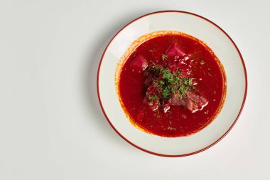 eastern European cuisine, traditional Ukrainian borsch with beef in ceramic bowl on grey backdrop clipart