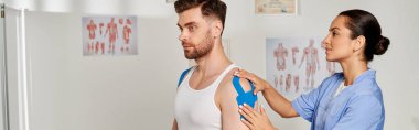 Doktoru Kinesio bantlarını üzerine yerleştirirken yakışıklı bir adam randevu sırasında oturuyor.