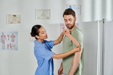 Yakışıklı hastasına kinezyolojik kasetler ve sağlık hizmetleri hakkında danışmanlık yapan çekici genç bir doktor.