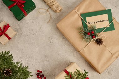 Gri desenli arka planda dekore edilmiş hediye kutularının yanında mutlu noel tebrik kartları, ziyafet teması