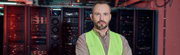 красивый преданный техник в бронежилете позирует и смотрит на камеру, дата-центр, баннер