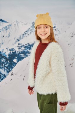 vertical shot of preadolescent girl in stylish winter attire smiling cheerfully at camera, fashion clipart