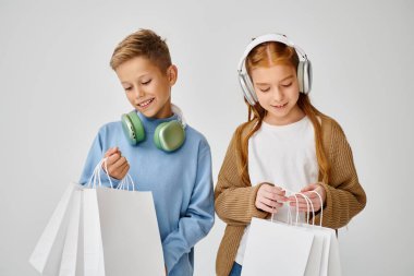 Kulaklıklı neşeli küçük arkadaşlar hediye çantalarına bakıyor, Kara Cuma, moda konsepti.