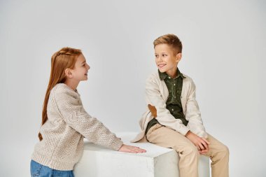 Şık, sıcak giysiler içinde birbirine gülümseyen neşeli ergen çocuklar, moda konsepti.