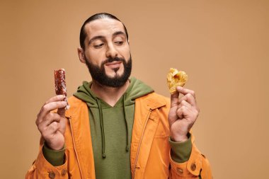 Neşeli sakallı adam gülümsüyor ve elinde baklava ve cevizli emici bej arka planda, Türk lezzetleri