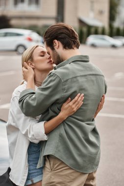 Şık giyinmiş romantik çift şehir sokaklarında dururken kucaklaşıyorlar, aşk hikayesi.