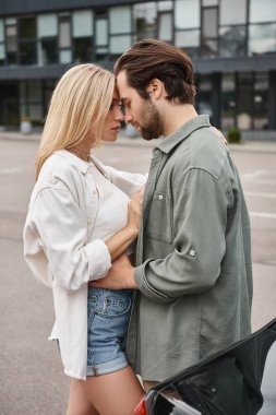 Romantik ve şık bir çift günlük giysiler içinde şehir caddesinde yüz yüze duruyorlar, aşk ilişkisi.