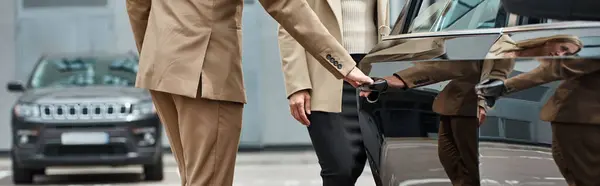 stock image partial view of man in elegant formal wear opening door of luxury car near businesswoman, banner