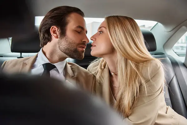 stock image stylish businessman and attractive blonde woman sitting face to face in luxury car, seduction