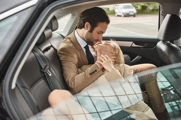 elegant and sensual business couple kissing with closed eyes while traveling in car, romance