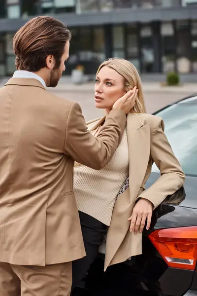 stock image elegant man in formal wear touching face of sensual blonde businesswoman near car on city street