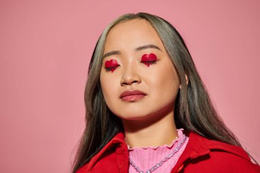 Sevgililer Günü konsepti, kalp şeklinde göz makyajı ve pembe gözleri olan genç Asyalı kadın.