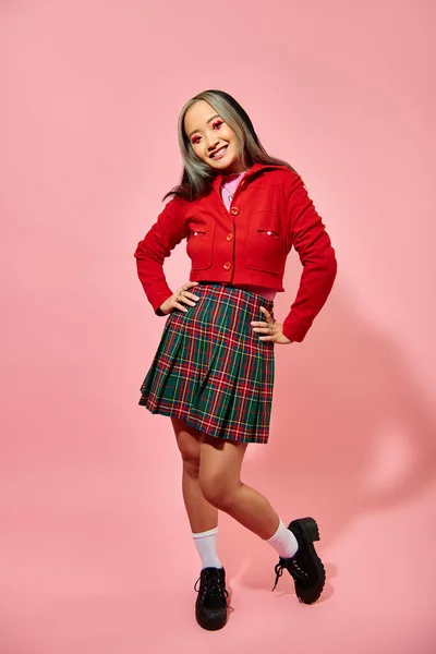情人节的概念 快乐的亚洲女孩穿着红色夹克 双手托着粉红背景的臀部 — 图库照片