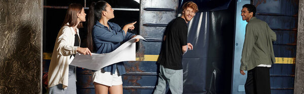 happy girls with map pointing at subway wagon and looking at friends while solving quest, banner