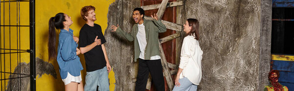 young african american man scaring his multicultural friends during quest in escape room, banner