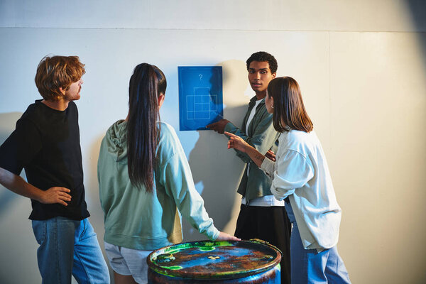 Африканский американец находит подсказку рядом с межрасовыми друзьями во время поисков в комнате для побега, тайна