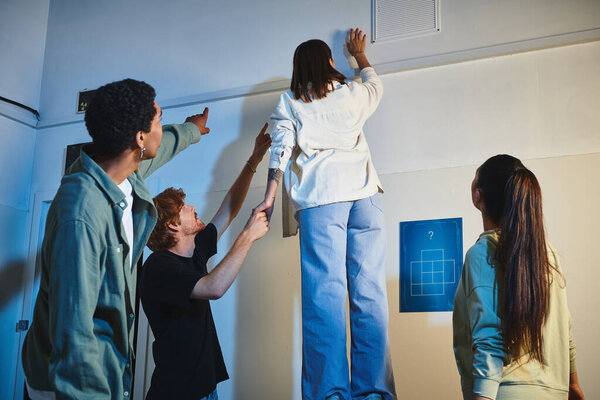 Два межрасовых мужчины указывают пальцами, показывая подсказку подруге, стоящей на бочке