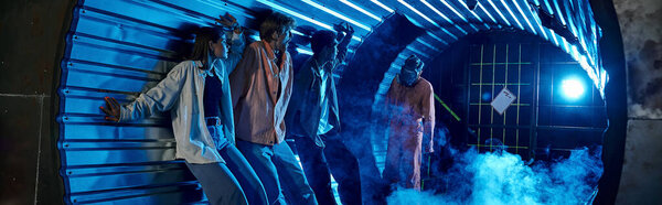 multiethnic friends standing in tunnel near freaky people in gas masks, quest room banner
