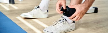 Modern Kinesio Merkezi 'nde antrenmandan önce spor kemeri takan adam manzarası.