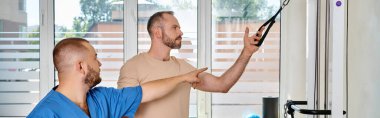 Mavi üniformalı yetenekli bir doktor Kinesio Center spor salonunda eğitmenlik yapıyor.