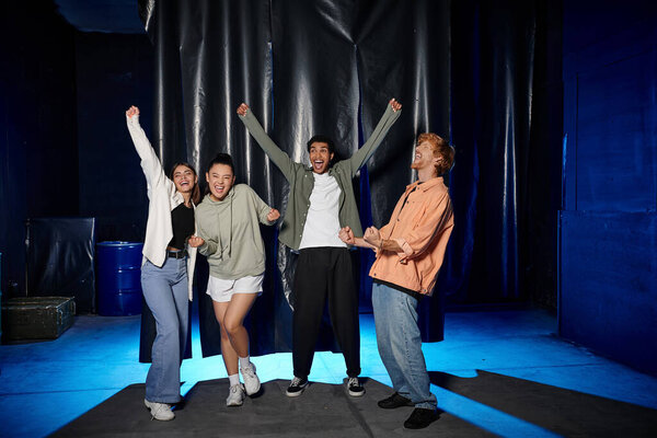 группа молодых мультикультурных друзей, празднующих успех в комнате побега вызов, радоваться