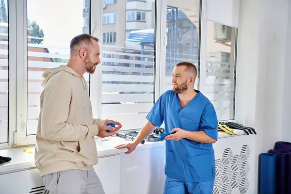 Junger Spezialist Blauer Uniform Gespräch Mit Seinem Männlichen Patienten Kinesio — Stockfoto