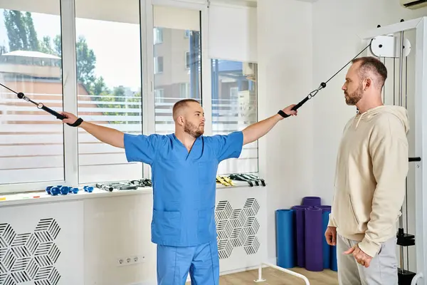 Kinesio Merkezi 'nde egzersiz makinesi üzerinde çalışan profesyonel iyileşme uzmanı.