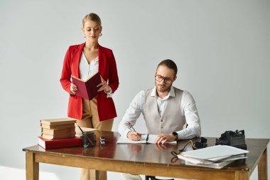Yakışıklı sakallı adam not alırken seksi sekreteri ona sevgiyle bakıyor, iş ilişkisi.