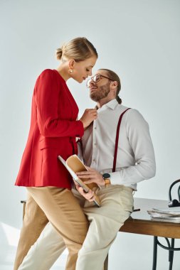 Aksesuarları ve şık stili olan, birbirlerini öpen ve birbirlerine bakan seksi bir çift. İş ilişkisi.