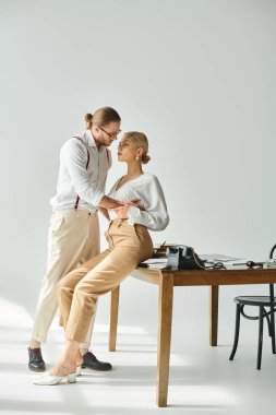 Yakışıklı sakallı adam iş yerinde güzel kız arkadaşını öpmeye hazırlanıyor.