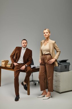 attractive young couple in elegant clothes posing together at office and looking at camera, affair clipart