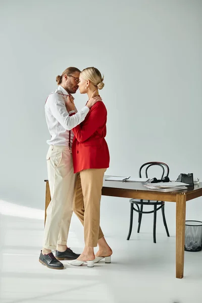 stock image sexy beautiful couple in chic attires posing and kissing lovingly while in their office, work affair