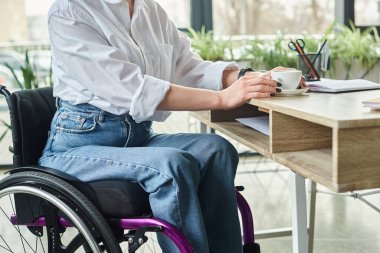 Tekerlekli sandalyedeki engelli bir iş kadınının ofiste sıkı çalışmasının kırpılmış görüntüsü.