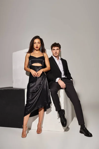 stock image Valentines day concept, attractive young couple in evening wear posing near cubes on grey background