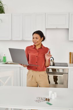 Mutlu Afro-Amerikan diyetisyeni laptopta online danışmanlık yapıyor ve ilaç öneriyor.