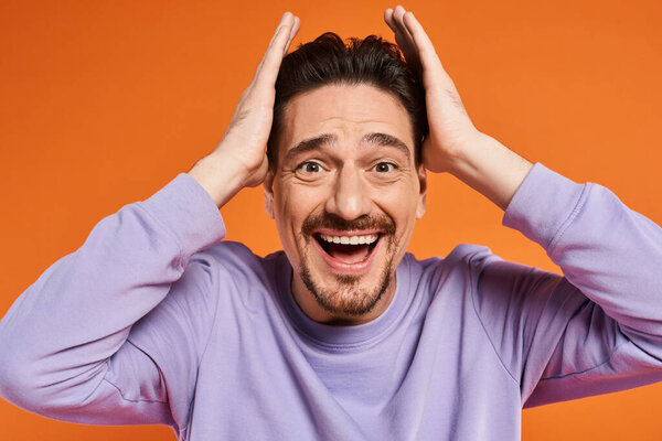 счастье, изумленный бородатый мужчина в фиолетовой толстовке улыбается с закрытыми глазами на оранжевом фоне