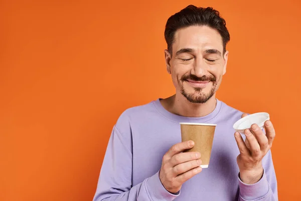 Wesoły Człowiek Brodą Trzymając Papierową Filiżankę Kawą Pomarańczowym Tle Przyjemność — Zdjęcie stockowe