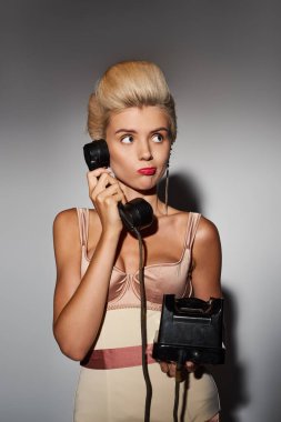 charming young woman with red lipstick puzzled conversation on retro phone in grey background clipart