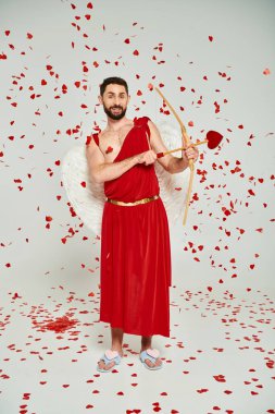 bearded man dressed as cupid archering from bow under heart-shaped confetti, st valentines party clipart
