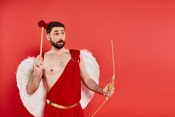 вдумчивый бородатый амур с луком и стрелой в форме сердца, глядя в сторону красного, Святого Валентина концепции