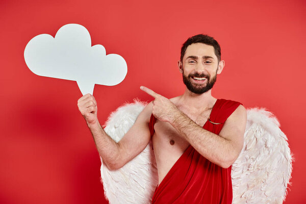 cheerful bearded man in cupid costume with white empty thought bubble showing idea sign on red