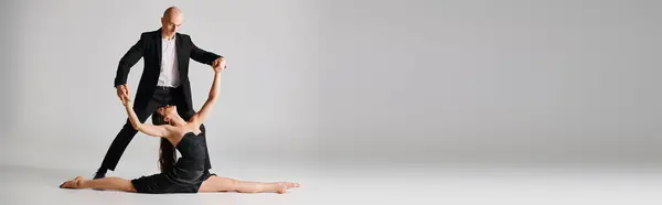 Mann Schwarzer Kleidung Unterstützt Weibliche Akrobatin Geteilter Pose Während Ihres — Stockfoto