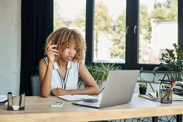年轻的非洲裔美国女商人在书桌上智能手机旁边的笔记本电脑上打手势 — 图库照片