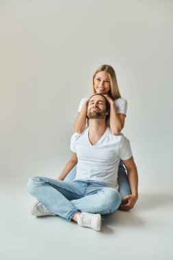 Kadın sırtüstü yatarken bir erkek yerde oturur ve seksi çift arasında hassas ve samimi bir an yaşar..