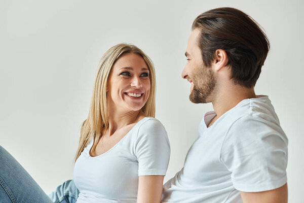 Чувственная пара, окутанная соблазнительной аурой романтики, сидящая близко друг к другу в интимном моменте.