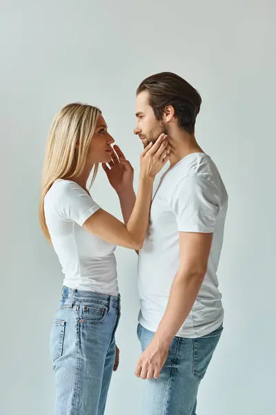 stock image A man and a woman, exuding sensuality and mystery, stand side by side in a tender embrace, expressing deep romantic connection.