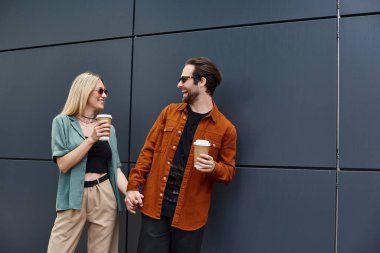 A man and woman standing intimately by a wall, sharing a moment of romance and connection. clipart