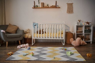 Akşamları ferah çocuk odasında beşiği ve yumuşak oyuncakları olan rahat ve rahat bir bebek odası.