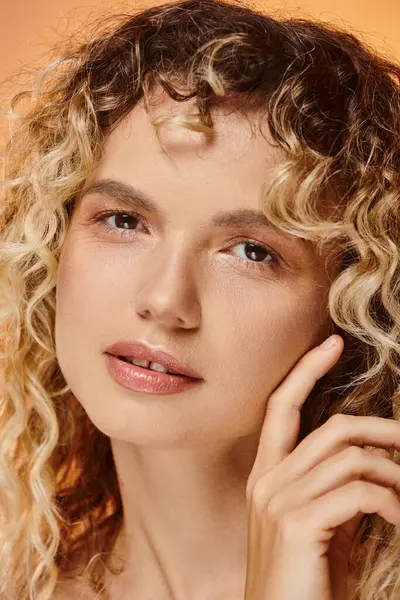 stock image close up portrait of curly woman with natural makeup and perfect skin looking at camera in studio