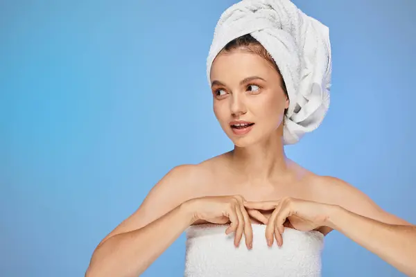 stock image sensual woman with perfect skin and towel on head looking away on blue backdrop, wellness and beauty